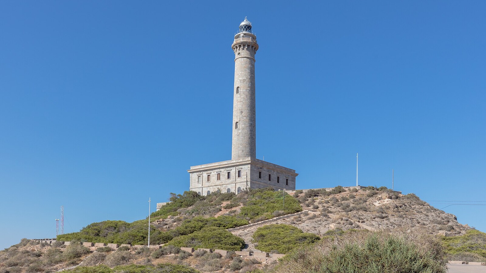 Leuchtturm von Cabo de Palos auf dem Hügel vor blauem Himmel. Wochenwetter an der Costa Blanca und der Costa Cálida vom 26. Oktober bis 1. November: 22 bis 25 Grad.