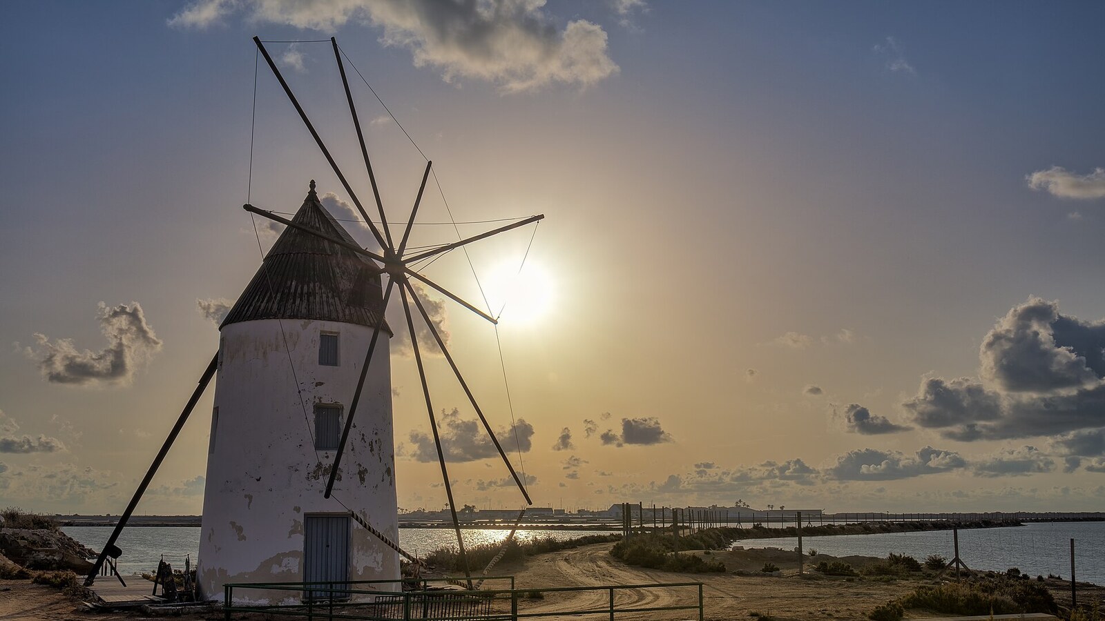 Windmühle an den Salinen von San Pedro del Pinatar im Gegenlicht, Mar Menor dahinter. Wochenwetter an der Costa Blanca und der Costa Cálida vom 5. bis 11. Oktober: 24 bis 27 Grad.