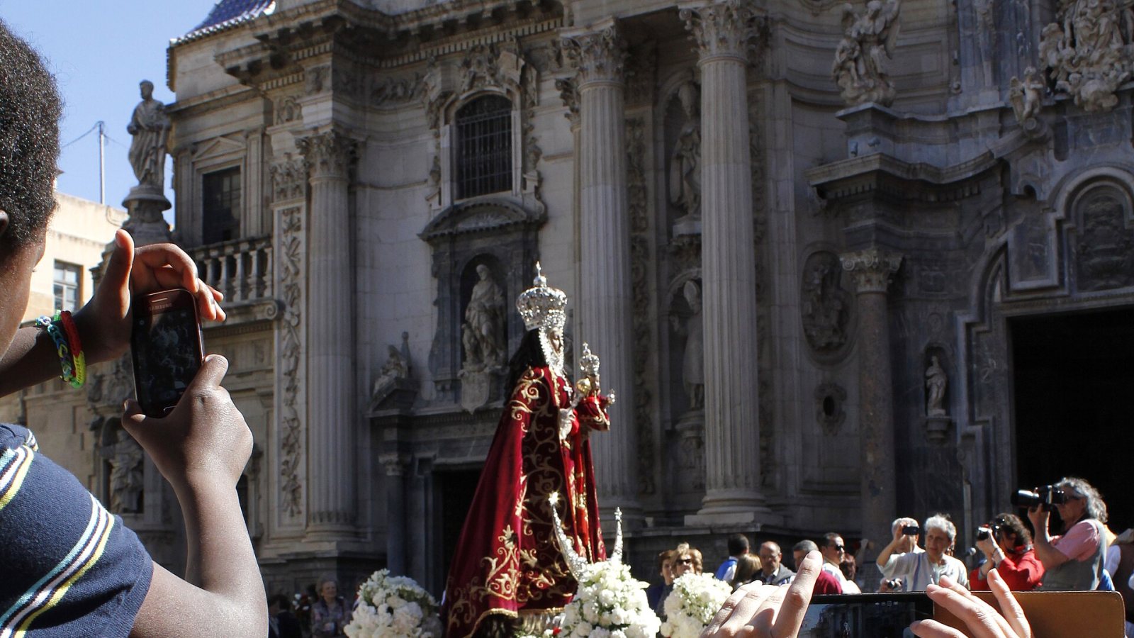 Marienfigur mit Blumenschmuck vor der Kathedrale von Murcia beim Bando de la Huerta, Zuschauer fotografieren.