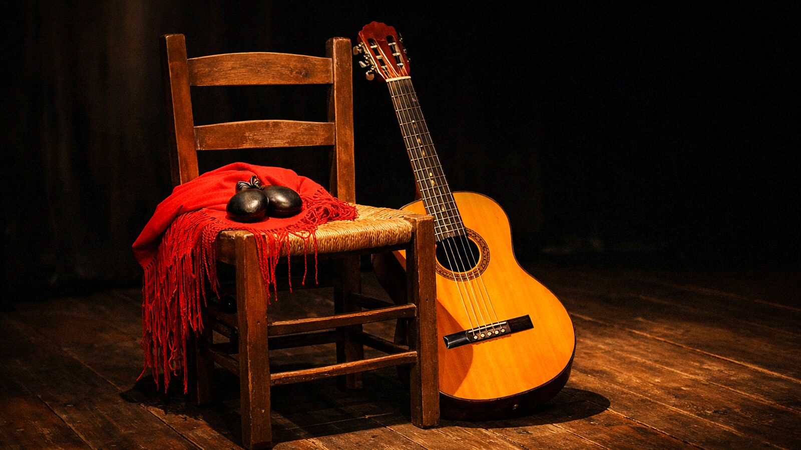 Spanische Gitarre, roter Schal und Kastagnetten auf einem Stuhl im Scheinwerferlicht, ohne Menschen (KI-Symbolbild).