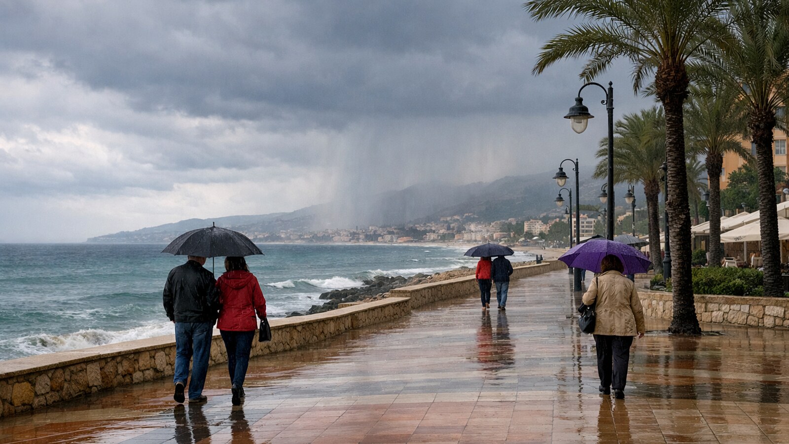 Zu sehen ist eine regennasse Uferpromenade an der Mittelmeerküste mit dunklen Wolken, leichtem Regen über dem Meer, Palmen und mehreren Fußgängern mit Regenschirmen (KI-Symbolbild).